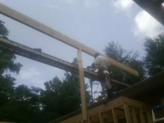 Carpenter setting a ridge beam over a new addition frame — Ice Dam Removal by Roofing Brothers in Laingsburg